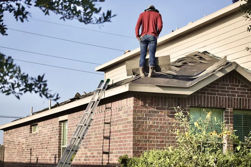 Professional roofer working on a residential roof in North Danville